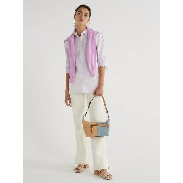 Model wearing button down shirt with white pants and lightweight pink cardigan