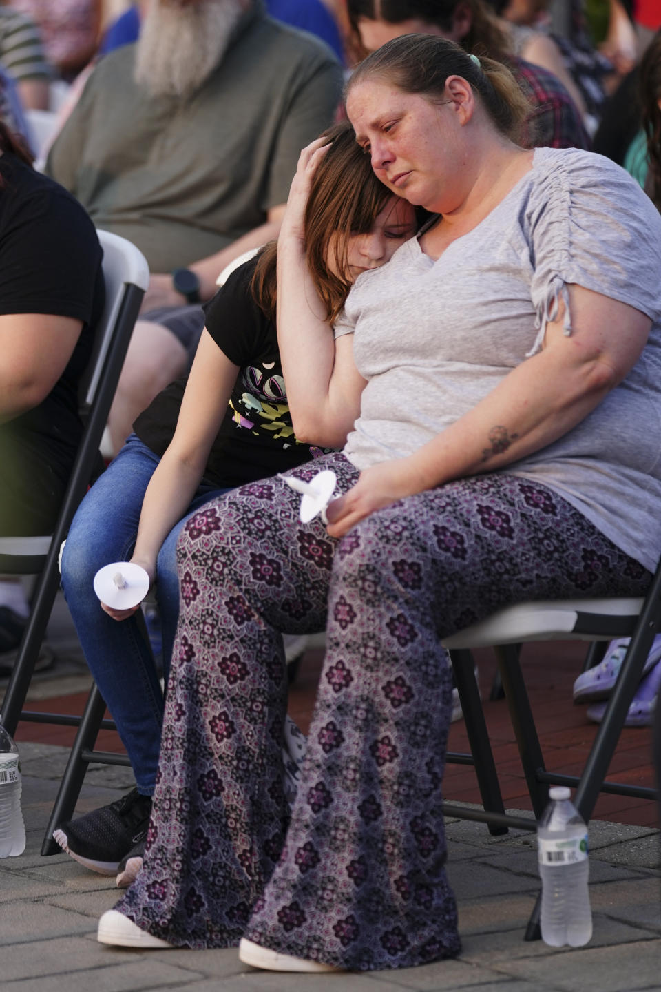 A woman and a child embrace during a vigil for the victims of Saturday's mass shooting on Monday, July 17, 2023, in Hampton, Ga. (AP Photo/John Bazemore)