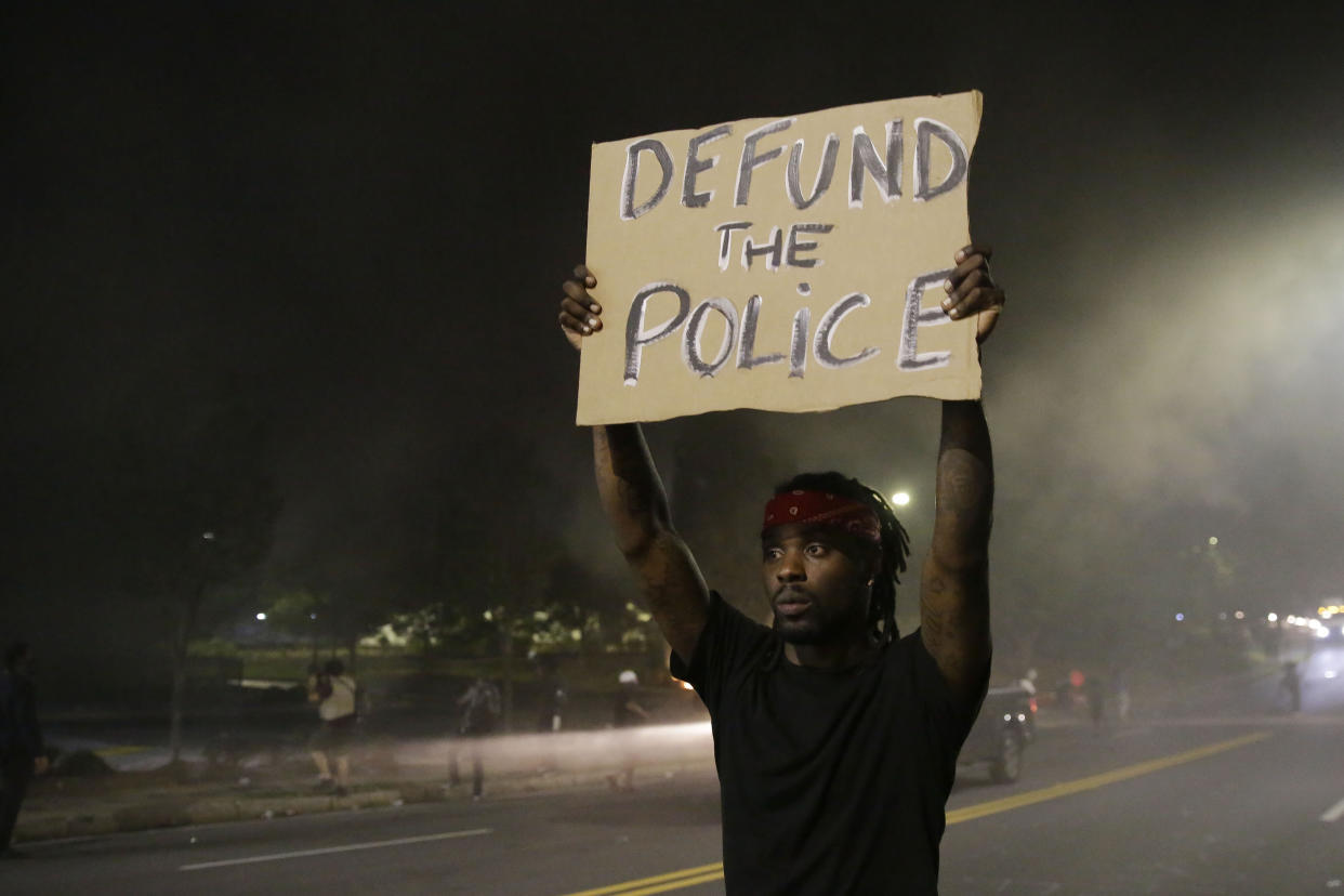 A man holds a sign during a protest near the Atlanta Wendy's where Rayshard Brooks was shot and killed by police. (Brynn Anderson/AP)