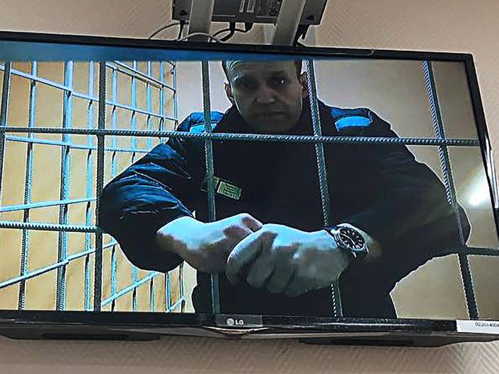 Russian opposition activist Alexei Navalny is seen on the screen during a hearing at the Petushki District Court on January 17, 2022..