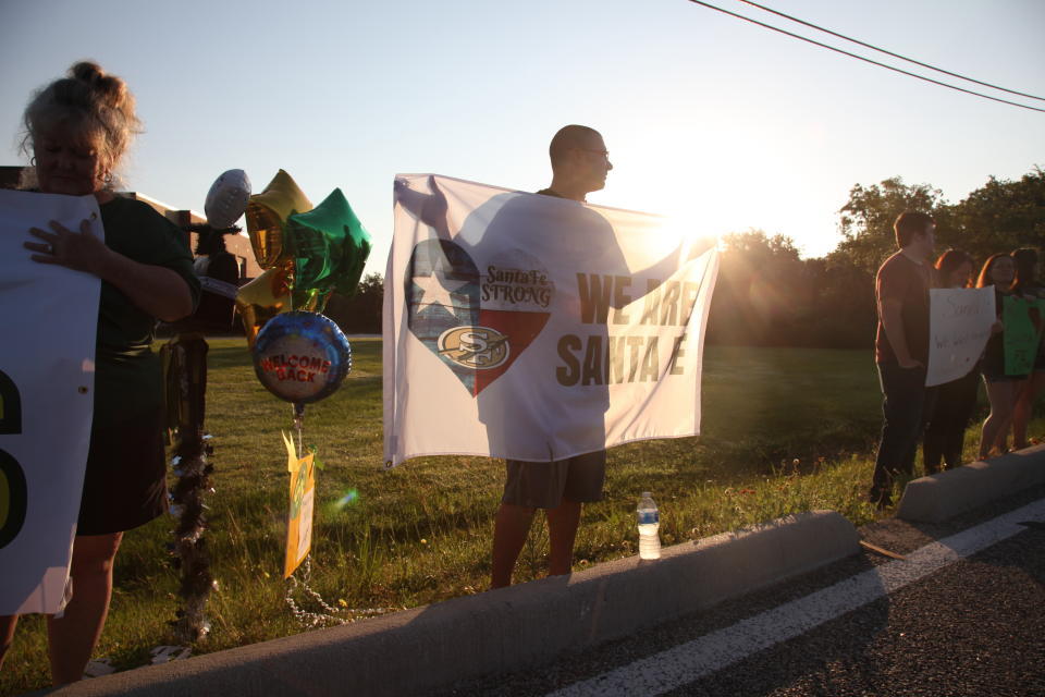 FILE - A man stands in front of Santa Fe High School, welcoming students back to class for the first time since a 17-year-old boy shot and killed ten people on campus, in Santa Fe, Texas, on May 29, 2018. Family members of those killed and injured during a 2018 attack at the Texas high school expressed concern Thursday, April 20, 2023, that the case against the accused gunman — delayed for years over questions of his mental competency — could be further held up pending removal of the trial judge, facing allegations of bias and prior legal ties to the defendant. (AP Photo/John L. Mone, File)