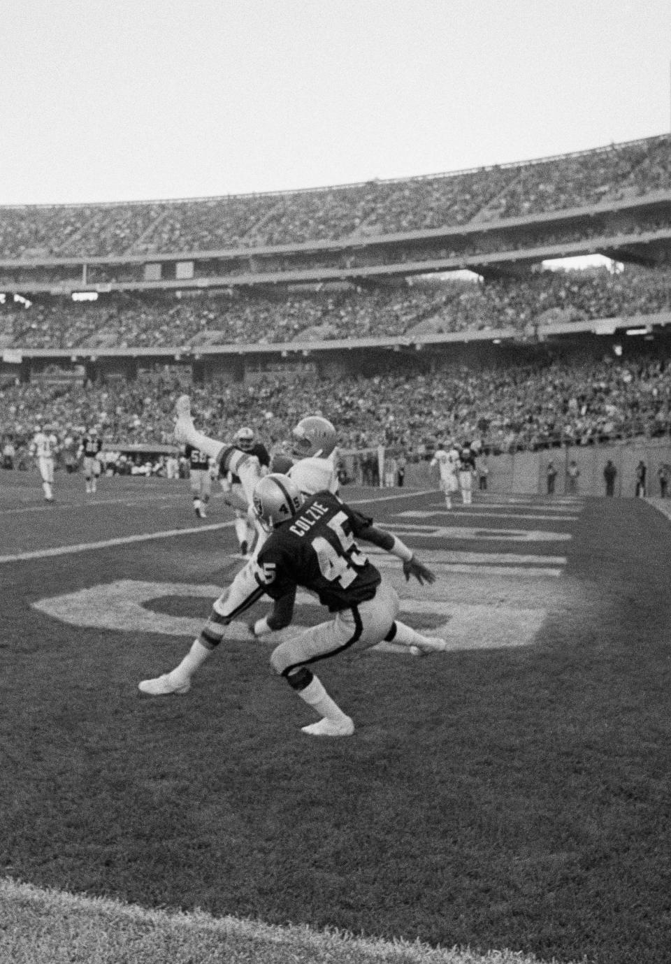 Isaac Curtis of the Cincinnati Bengals gathers in a touchdown pass from quarterback Ken Anderson in the fourth quarter of the AFC Playoff at Oakland, Dec. 28, 1975. The touchdown made the score: Cincinnati 27, Oakland 31. That's Neal Colzie of the Raiders moving in on the receiver. Oakland won, 31-28, and meets Pittsburgh for the AFC championship.