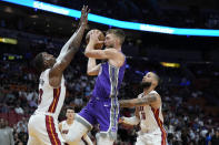 Sacramento Kings center Domantas Sabonis, center, goes up for a shot against Miami Heat center Bam Adebayo (13) and forward Caleb Martin (16) during the first half of an NBA basketball game, Wednesday, Nov. 2, 2022, in Miami. (AP Photo/Wilfredo Lee)