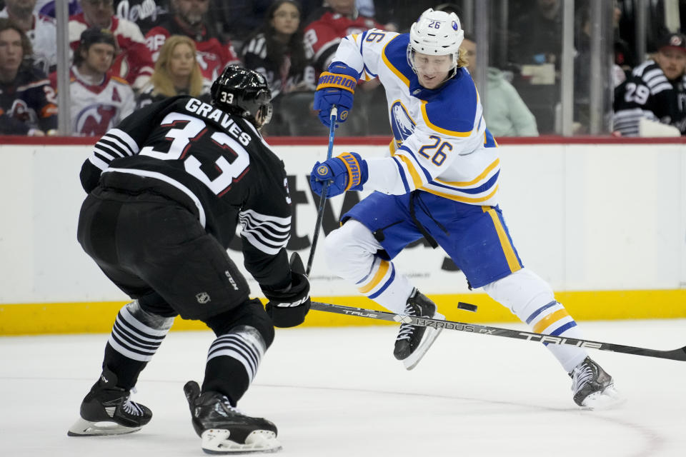 Buffalo Sabres defenseman Rasmus Dahlin (26) takes a shot on goal against New Jersey Devils defenseman Ryan Graves (33) during first period of an NHL hockey game, Tuesday, April 11, 2023, in Newark, N.J. (AP Photo/John Minchillo)