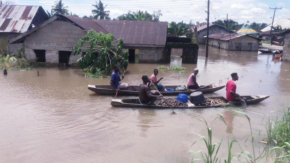 People paddle their canoes along flooded residential streets after a heavy downpour In Bayelsa, Nigeria, Thursday, Oct. 20, 2022. More than 600 people have been killed so far this year and 1.3 million forced from their homes by Nigeria’s worst floods in a decade. Authorities are blaming the disaster on unusually heavy rainfall and the release of excess water from the Lagdo dam in neighboring Cameroon. (AP Photo/Reed Joshua)