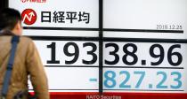 CORRECTS DATE - A man looks at the day's loss of Nikkei stock index on an electronic stock board at a securities firm in Tokyo, Tuesday, Dec. 25, 2018. Japanese stocks plunged Tuesday and other Asian markets declined following heavy Wall Street losses triggered by President Donald Trump's attack on the U.S. central bank. (Yohei Fukai/Kyodo News via AP)