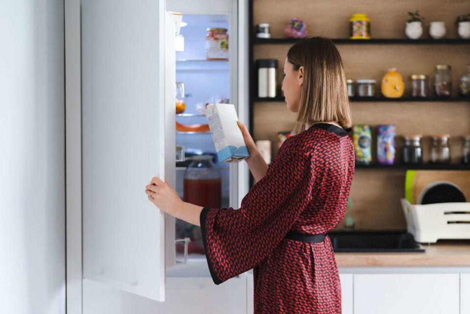 Over/under fridge freezer with woman looking at food