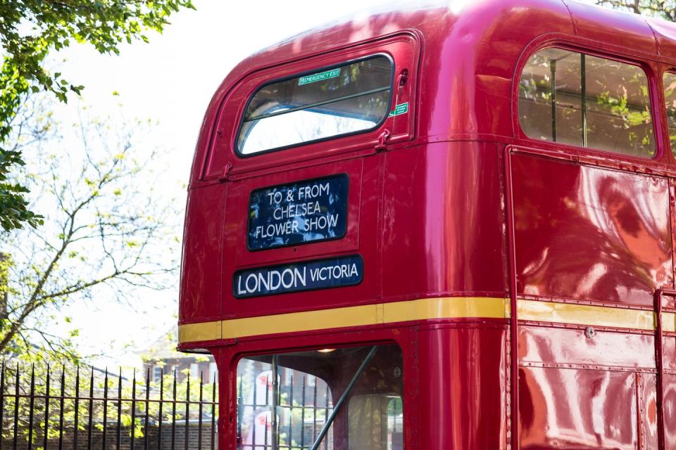 close up color image depicting an iconic red double decker london bus escorting tourists and customers to the chelsea flower show the rhs chelsea flower show, formally known as the great spring show, is a garden show held for five days in may by the royal horticultural society rhs in the grounds of the royal hospital chelsea in chelsea, london on the street, people are about to board the bus room for copy space