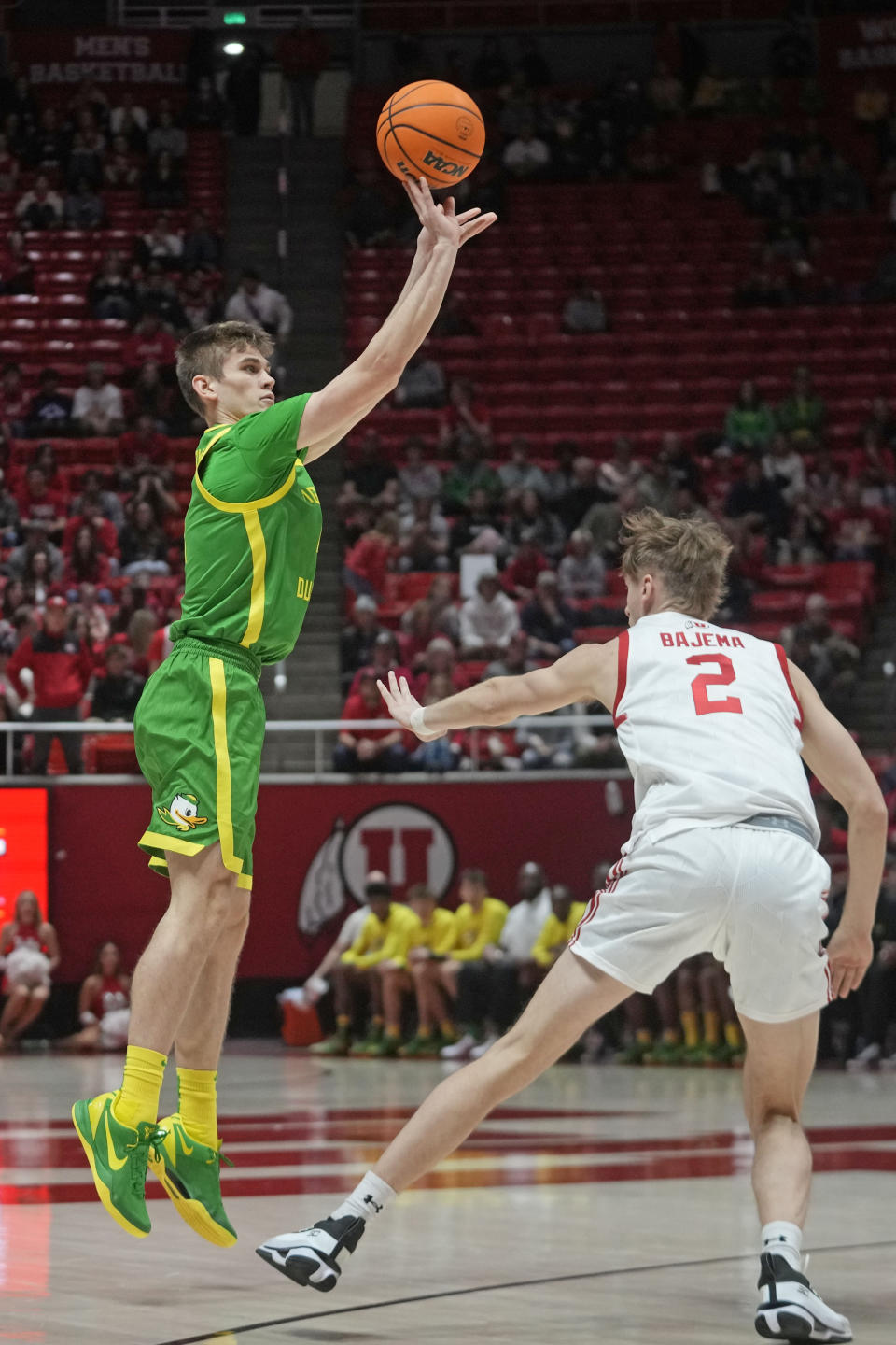 Oregon guard Brennan Rigsby, left, shoots as Utah guard Cole Bajema (2) defends during the first half of an NCAA college basketball game, Sunday, Jan. 21, 2024, in Salt Lake City. (AP Photo/Rick Bowmer)