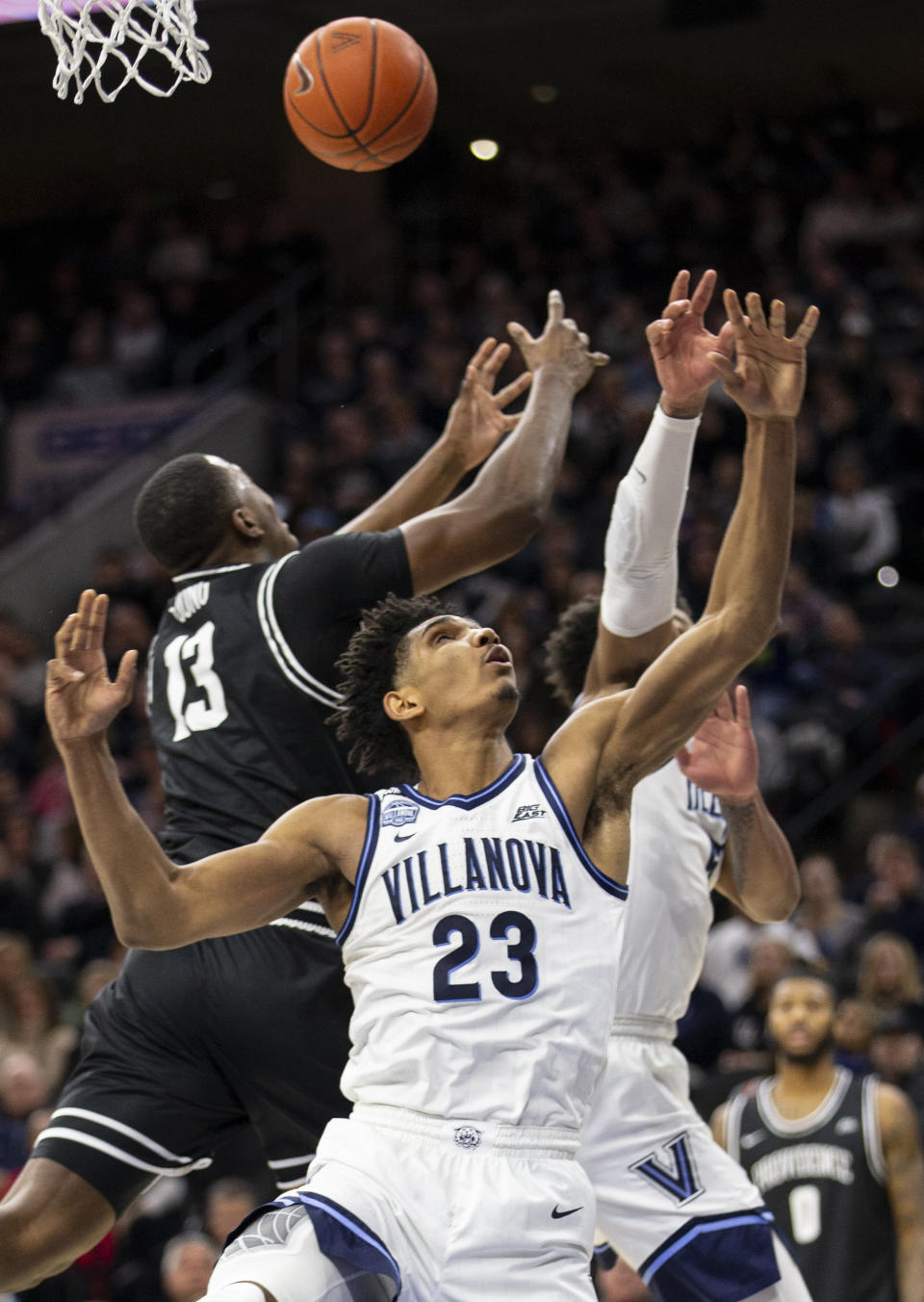 Villanova forward Jermaine Samuels (23) and Providence forward Kalif Young (13) reach for a rebound during the second half of an NCAA college basketball game, Saturday, Feb. 29, 2020, in Philadelphia. Providence won 58-54. (AP Photo/Laurence Kesterson)