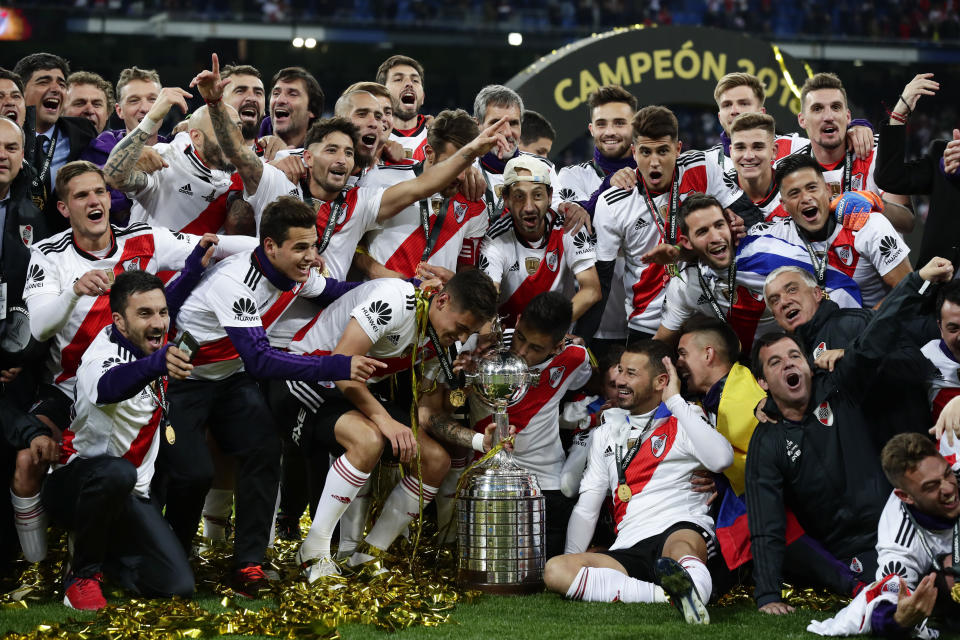 Players of Argentina's River Plate celebrate with the trophy after beating Argentina's Boca Juniors in the Copa Libertadores final soccer match at the Santiago Bernabeu stadium in Madrid, Spain, Sunday, Dec. 9, 2018. (AP Photo/Manu Fernandez)