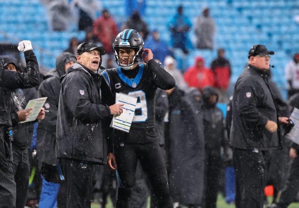 Carolina Panthers quarterback Bryce Young, right, talks to coach Chris Tabor at the Bank of America Stadium in Charlotte, N.C., on Sunday, December 17, 2023. Khadejeh Nikouyeh/Knikouyeh@charlotteobserver.com