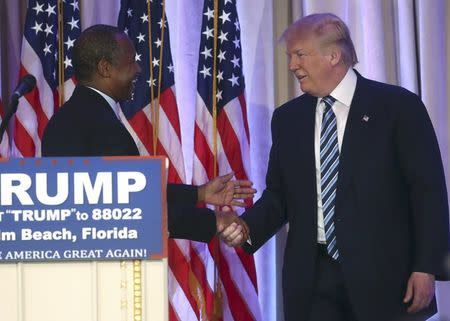 Republican U.S. presidential candidate Donald Trump (R) shakes hands with former Republican presidential candidate Ben Carson after receiving Carson's endorsement at a campaign event in Palm Beach, Florida March 11, 2016. REUTERS/Carlo Allegri