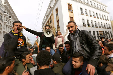 Demonstrating graduate students shout slogans, as riot police stand guard, during protests against rising prices and tax increases, in Tunis, Tunisia January 12, 2018. REUTERS/Zoubeir Souissi