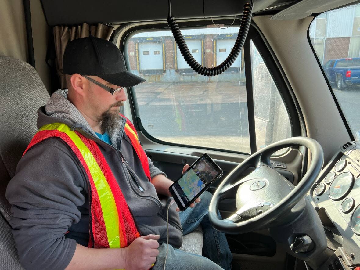 Lighthouse Transportation driver Chris Peckford is shown in his truck with the electronic logging device he now uses. (Paul Poirier/CBC News - image credit)