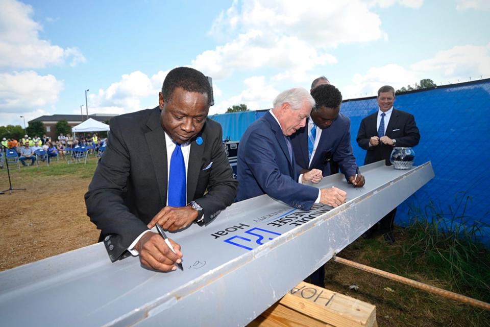 MTSU President Sidney A. McPhee, left, and MTSU Board of Trustees members J.B. Baker, left, Darrell Freeman, Steve Smith and Pete Delay sign the ceremonial final beam to be placed at the top of the School of Concrete and Construction Management building Tuesday, Sept. 14, in the Bragg Parking lot adjacent to the construction site. (MTSU photo by J. Intintoli)