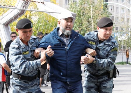 Kazakh law enforcement officers detain a man during a rally held by opposition supporters in Nur-Sultan