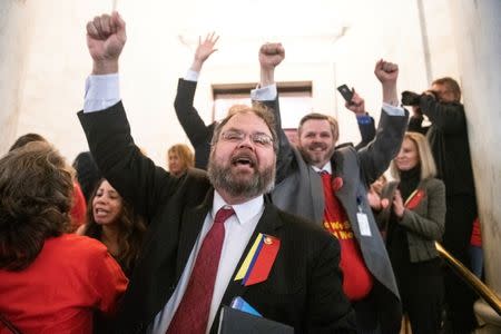 Senator John Unger (D-WV) raises his hands in victory before a crowd of striking teachers as lawmakers rejected a bill that would have opened the first charter schools in the state, at the Capitol building in Charleston, West Virginia, U.S., February 19, 2019. REUTERS/Lexi Browning