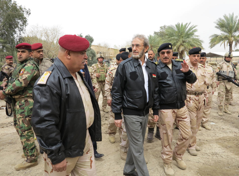 In this photo released by the Iraqi Army taken on March 20, 2014, Iraq's acting Minister of Defense Saadoun al-Dulaimi, center, walks with Lt. Gen. Ali Ghaidan, center left, commander of the army's ground forces and the commander of Anbar Operations, Lt. Gen. Rasheed Fleih, center right, in Ramadi, 70 miles (115 kilometers) west of Baghdad, Iraq. Iraqi military officials are warning that efforts to clear militants from Fallujah and parts of nearby Ramadi are proving much more difficult than they anticipated when the jihadists showed up three months ago. That realization, as they acknowledged during a recent tour of special forces operations, casts doubt on Iraq's ability to hold elections in Fallujah next month. (AP Photo/Iraqi Army)