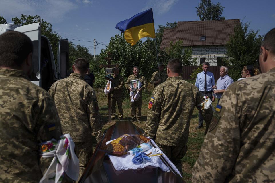 A guard of honour carry the coffin of their comrade Volodymyr Grechanyi, a Ukrainian serviceman, during the funeral ceremony in the village of Putrivka, Ukraine, Thursday, Aug. 1, 2024. Grechanyi was killed in fighting with the Russian army at the frontline in Vovchansk on July 23rd. (AP Photo/Evgeniy Maloletka)