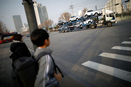 Children look at a truck transporting newly manufactured GM vehicles outside its Bupyeong plant in Incheon, South Korea March 12, 2018. REUTERS/Kim Hong-Ji