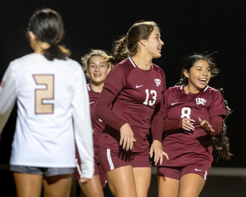 Granite Hills' Samantha Grantham, center, celebrates with Carina Duran after scoring a goal against Adelanto during the first half on Thursday, Jan. 27, 2022.