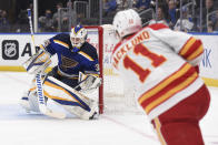 Calgary Flames center Mikael Backlund (11) scores a goal past St. Louis Blues goaltender Ville Husso (35) during the first period of an NHL hockey game Thursday, Jan. 27, 2022, in St. Louis. (AP Photo/Joe Puetz)