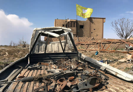 A Syrian Democratic Forces flag flutters on a damaged building in the village of Baghouz, Deir Al Zor province, Syria, March 23, 2019. REUTERS/Stringer