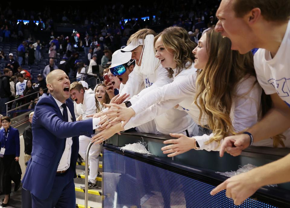 Brigham Young’s head coach Mark Pope celebrates the win with students as BYU defeats Utah.