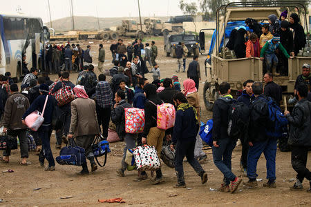 Displaced Iraqi people who fled their homes during a battle between Iraqi forces and Islamic State militants, arrive at a checkpoint to be transfer to Hammam al-Alil camp, in Mosul, Iraq, March 20, 2017. REUTERS/Thaier Al-Sudani