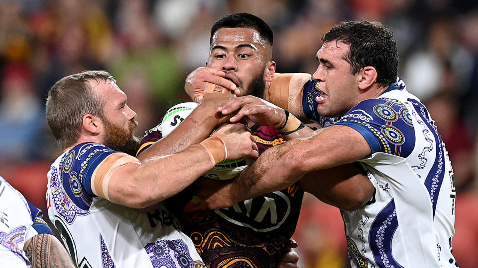 Brisbane's Payne Haas is seen here being tackled by Melbourne Storm players.