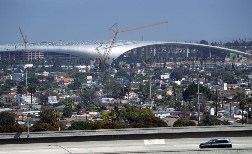 Freeway traffic passes in front of the SoFi Stadium, the new home of the NFL's Los Angeles Chargers and Rams, while still under construction in Inglewood, Calif. on Wednesday, March 4, 2020. The Rams and Chargers are expected to play August preseason games at SoFi Stadium, the completion of which was already delayed a year because of the amount of rain the region received in 2018-2019.(AP Photo/Richard Vogel)