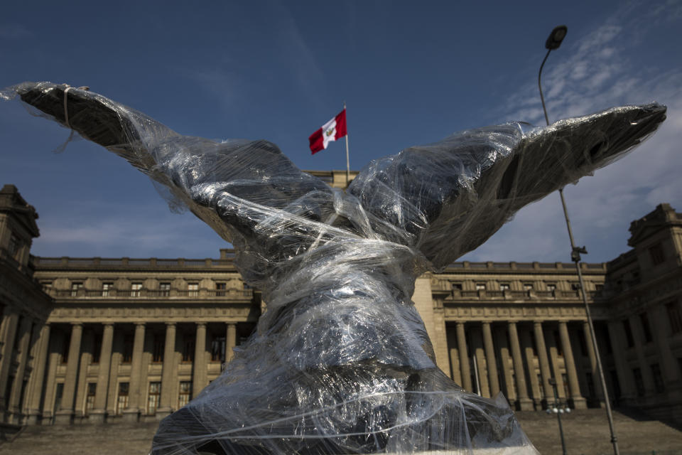 A sculpture of an eagle that sits in front of Justice Palace is wrapped in plastic, in Lima, Peru, Saturday, Nov. 21, 2020. Monuments were practically spared, in part because they were protected with plastic or fabrics, but also because they were not the aim of protesters as they filled the streets, decrying a parliamentary coup in early November when Congress voted to oust ex-President Martín Vizcarra. (AP Photo/Rodrigo Abd)