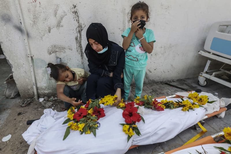 A Palestinian woman and children mourn over a body recovered from the grounds of Nasser Hospital compound, after the Israeli Defense Forces (IDF) withdrew from the area in Khan Yunis, southern Gaza Strip. Omar Naaman/dpa