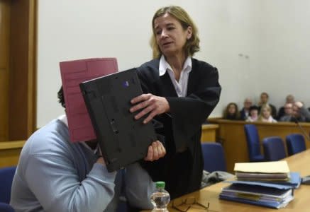 FILE PHOTO: Former nurse Niels H. (L) masks his face with a folder with the help of his lawyer Ulrike Baumann on his arrival in the courtroom at the regional court in Oldenburg, December 9, 2014.        REUTERS/Fabian Bimmer