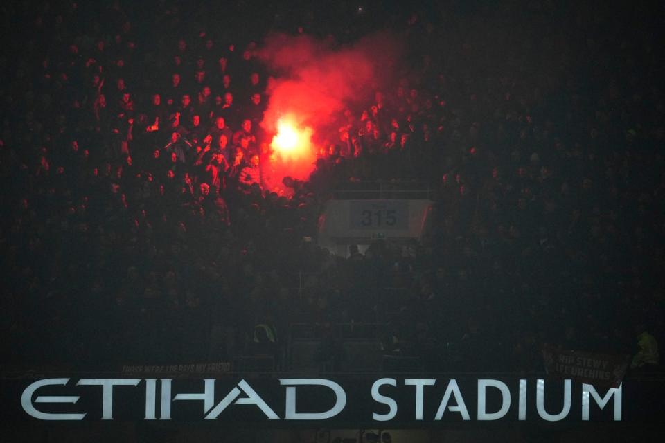 A flare goes off in the stands during Manchester City’s Carabao Cup tie with Liverpool (AP)