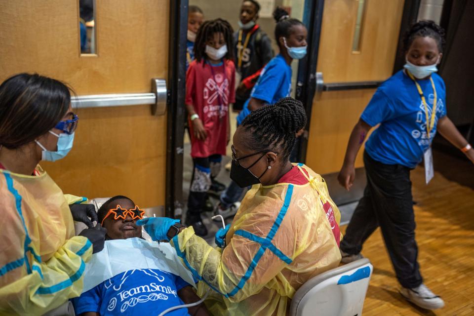 Brenda Scott Academy students make their way into the gym as a student gets dental work done, during an event at Brenda Scott Academy in Detroit on Friday, June 10, 2022. Detroit District Dental Society joined the Detroit Lions and Team Smile as volunteer dentists and dental staff to provide free dental care to students.