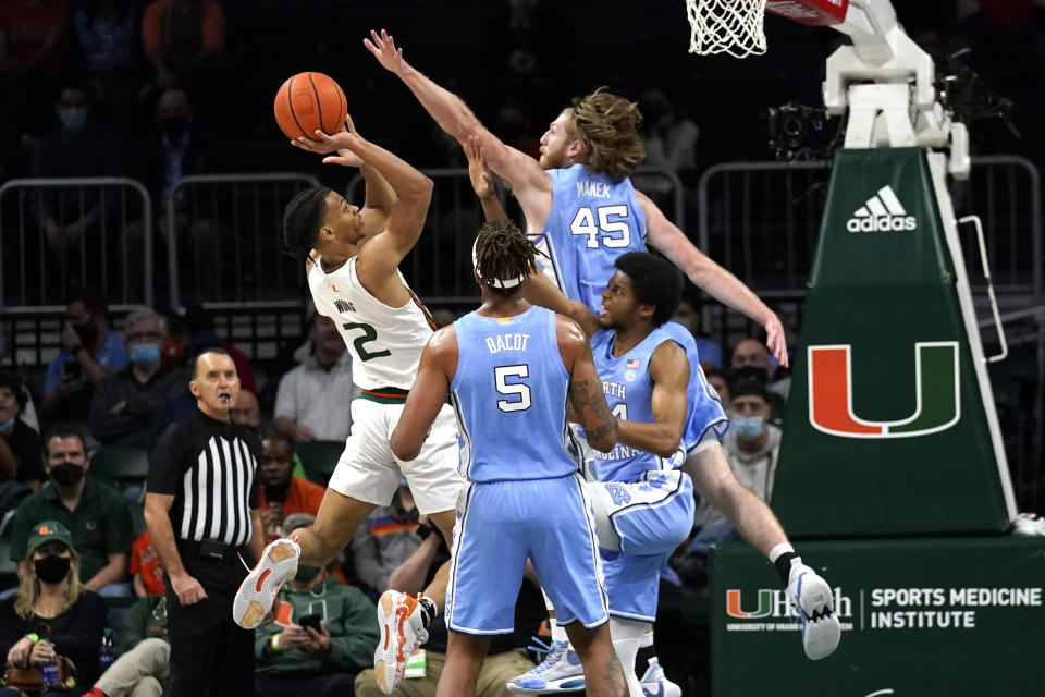 Miami guard Isaiah Wong (2) shoots as North Carolina forward Brady Manek (45) defends during the first half of an NCAA college basketball game, Tuesday, Jan. 18, 2022, in Coral Gables, Fla. (AP Photo/Lynne Sladky)