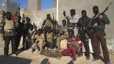 Masked Sunni Muslim gunmen pose for a photo during a patrol in the city of Falluja, 70 km (44 miles) west of Baghdad, in this February 8, 2014 file photo. REUTERS/Stringer/Files