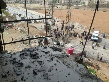 People inspect the site of a car bomb on the outskirts of the Sayeda Zeinab district south of Damascus, Syria in this handout picture provided by SANA on April 25, 2016. REUTERS/SANA/Handout via Reuters