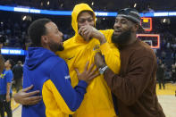 Golden State Warriors' Stephen Curry, left, greets Los Angeles Lakers' Anthony Davis, center, and LeBron James, right, after an NBA preseason basketball game in San Francisco, Saturday, Oct. 7, 2023. (AP Photo/Jeff Chiu)