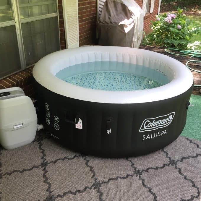 Inflatable Coleman SaluSpa hot tub on a patio beside a small white cooler