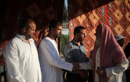 Palestinians shake hands during a reconciliation ceremony in Khan Younis in the southern Gaza Strip August 31, 2017. Picture taken August 31, 2017. REUTERS/Ibraheem Abu Mustafa