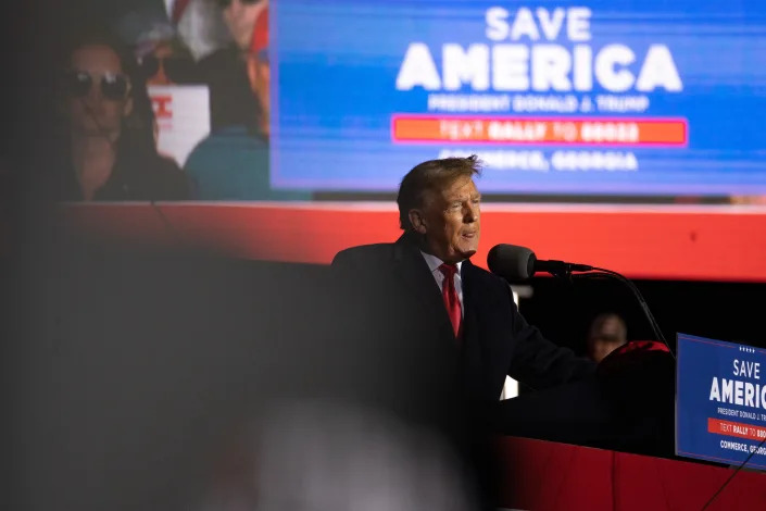 Former President Donald Trump at a rally at a rally on March 26 in Commerce, Georgia, in front of a sign reading 