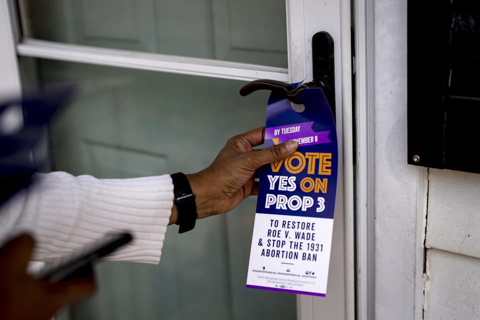 Darci McConnell places a door tag in support of Proposal 3 on a door in Plymouth, Michigan, on Oct. 30, 2022. / Credit: Nic Antaya for The Washington Post via Getty Images