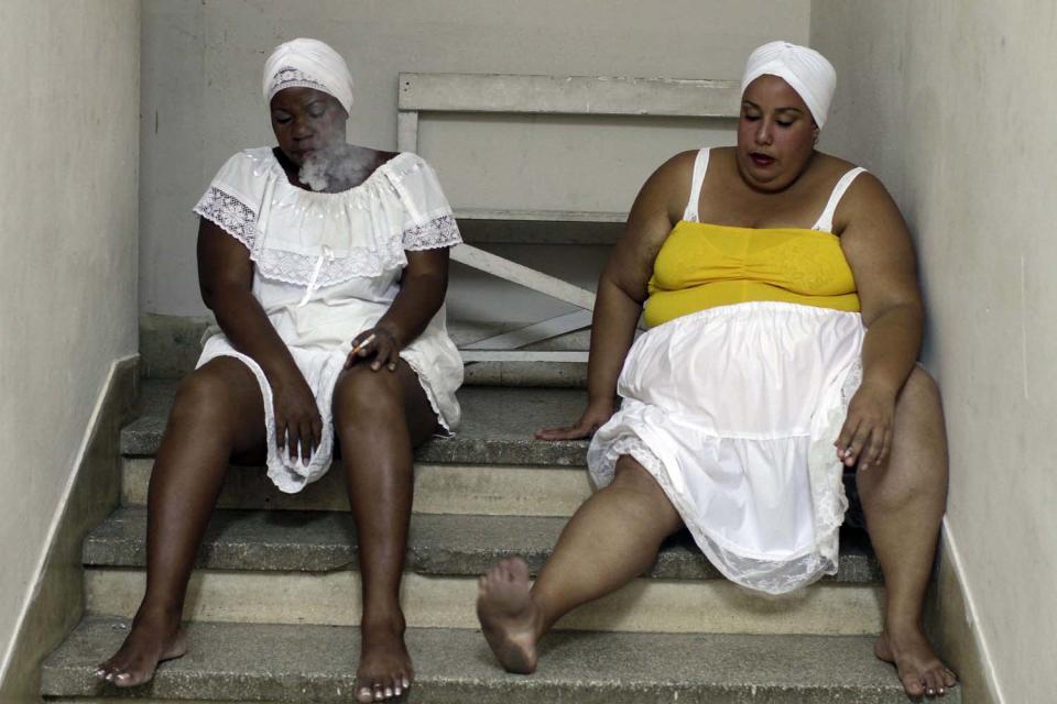 Maylin Daza acompaña a Xiomara González, mientras se funa un cigarrillo, antes de la presentación de "Crisálidas", con el grupo "Danza Voluminosa". AP Photo/Franklin Reyes