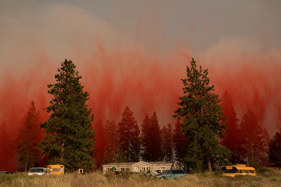 Fire retardant dropped from an airplane falls to the ground near the Chuweah Creek Fire as wildfires devastate Nespelem, Wash. on July 14.<span class="copyright">David Ryder—Reuters</span>