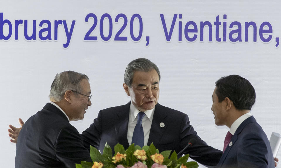 China's Foreign Minister Wang Yi, center, talks with Philippines Foreign Affaires Secretary Teodoro Locsin Jr., left and Laos Foreign Minister Saleumxay Kommasith following a joint press conference of the Co-Chairs Special ASEAN-China Foreign Ministers' meeting on the Novel Coronavirus Pneumonia in Vientiane, Laos, Thursday, Feb. 20, 2020. (AP Photo/Sakchai Lalit)