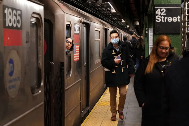 A person wears a surgical mask in the subway station at Times Square in New York