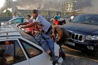 An injured man lies at the back of a car before being rushed away from the scene of a massive explosion at the port of Lebanon's capital Beirut on August 4, 2020. - Two huge explosion rocked the Lebanese capital Beirut, wounding dozens of people, shaking buildings and sending huge plumes of smoke billowing into the sky. Lebanese media carried images of people trapped under rubble, some bloodied, after the massive explosions, the cause of which was not immediately known. (Photo by Marwan TAHTAH / AFP) (Photo by MARWAN TAHTAH/AFP via Getty Images)